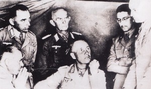 Rommel bersama beberapa stafnya dan perwira-perwira Italia. Berada dibelakang Rommel adalah Oberst Diesener. Sementara pada posisi paling kanan adalah General Gause. Duduk di posisi kanan adalah perwira Italia, General Navarini